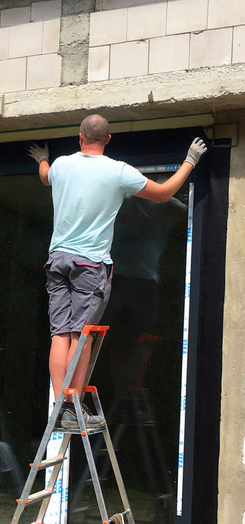 Naklejanie od strony zewnętrznej szczelnego fartucha z EPDM. Fot. MULTIKO ARCHITEKTURA OKIEN