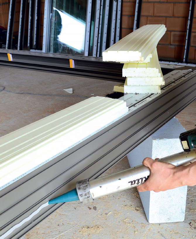 akładanie kleju hybrydowego na spód progu drzwi